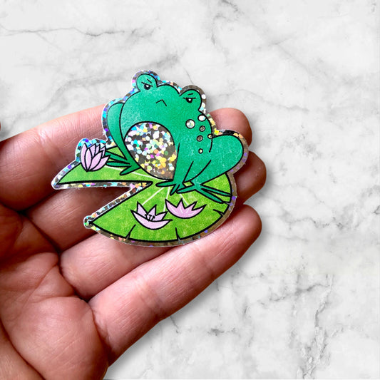 Angry Frog glitter sticker. Perfect for adding sparkle to laptops, notebooks, and water bottles. A fun gift for frog lovers and sticker fans.