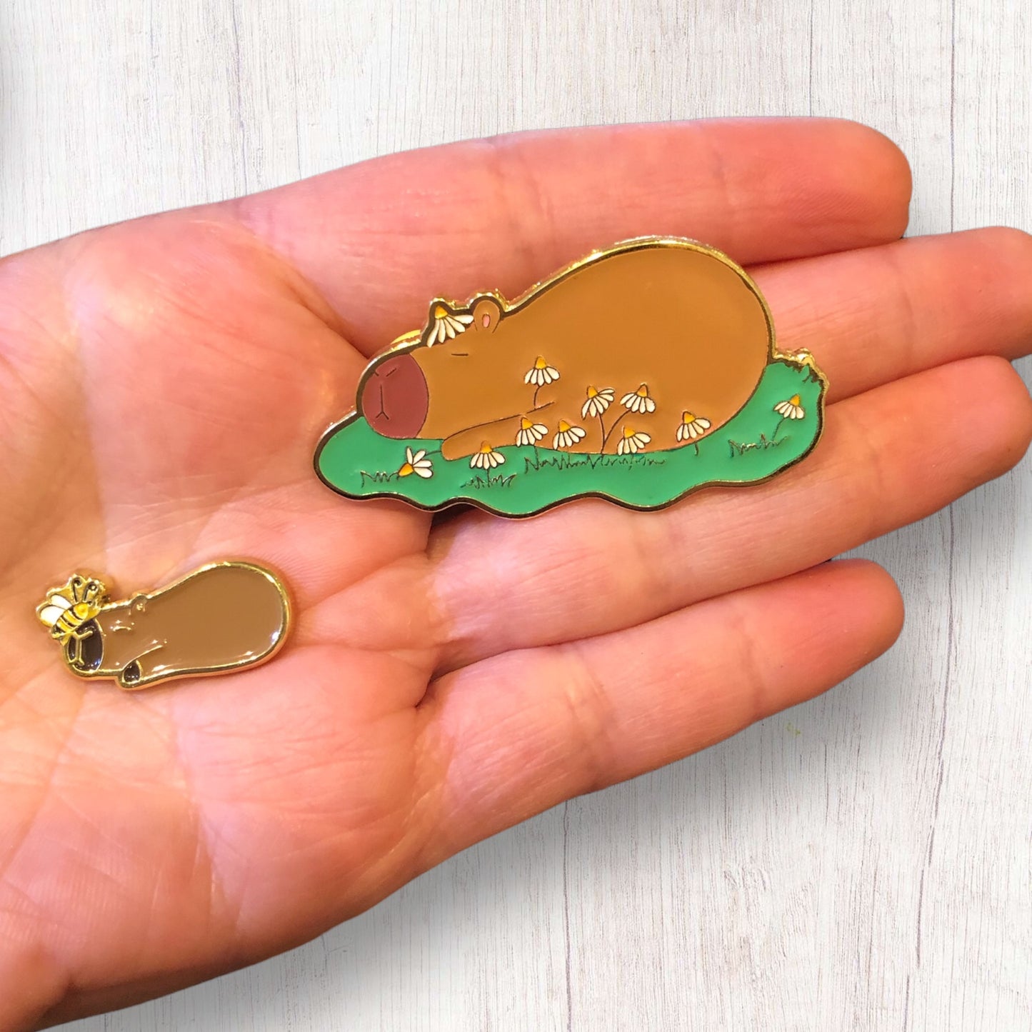 capybara pin with magnetic part de-attached, in hand to show scale