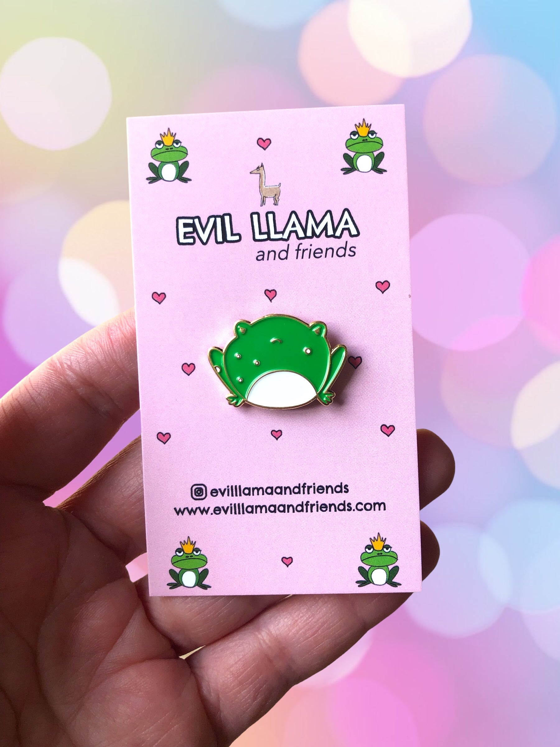 angry frog pin with pink backing card, in hand, to show scale