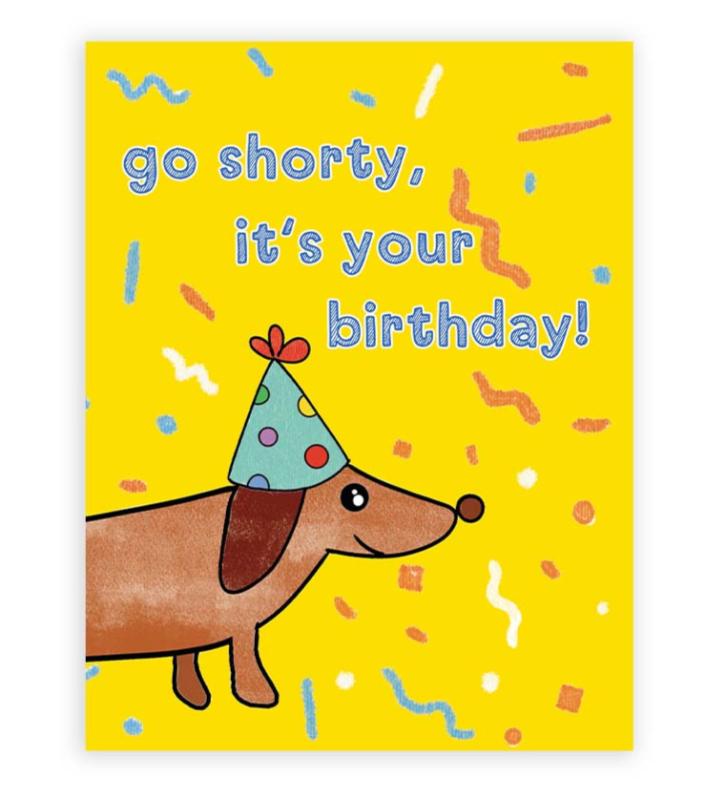 dachshund birthday card showing cute dachshund in a festive hat. the text reads "go shorty, it's your birthday"