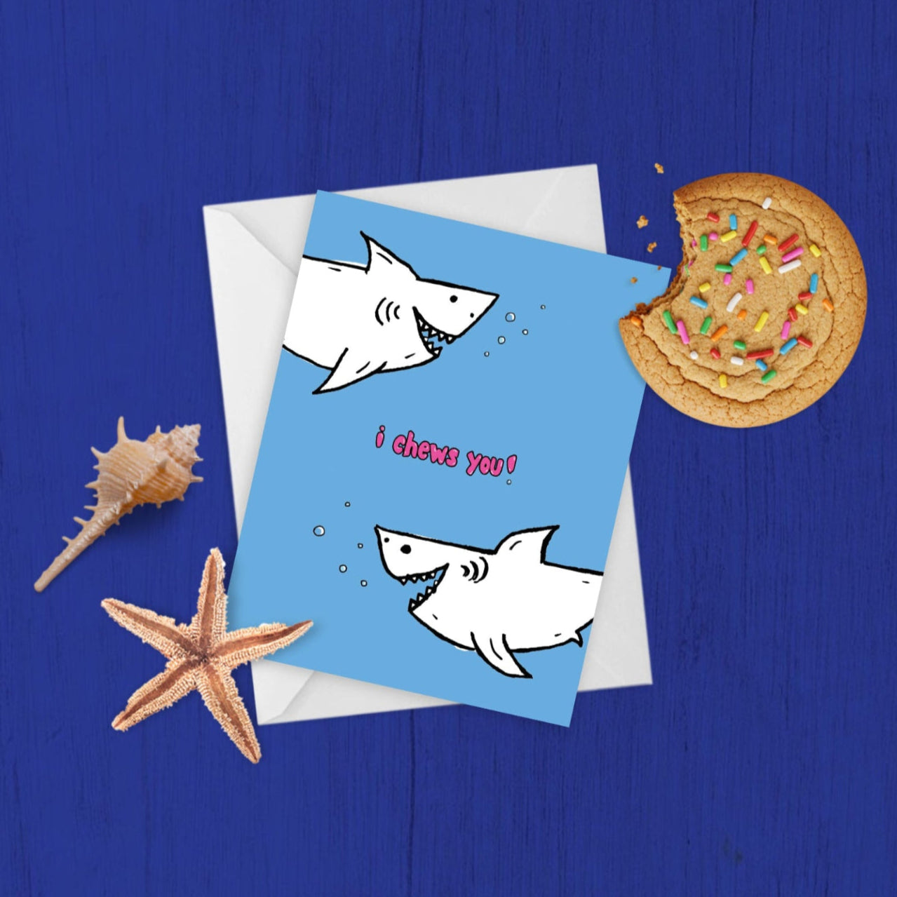 i chews you punny shark card styled against a blue background, with sea shell and starfish, and a cookie with a bite taken out of it, because "chew"!