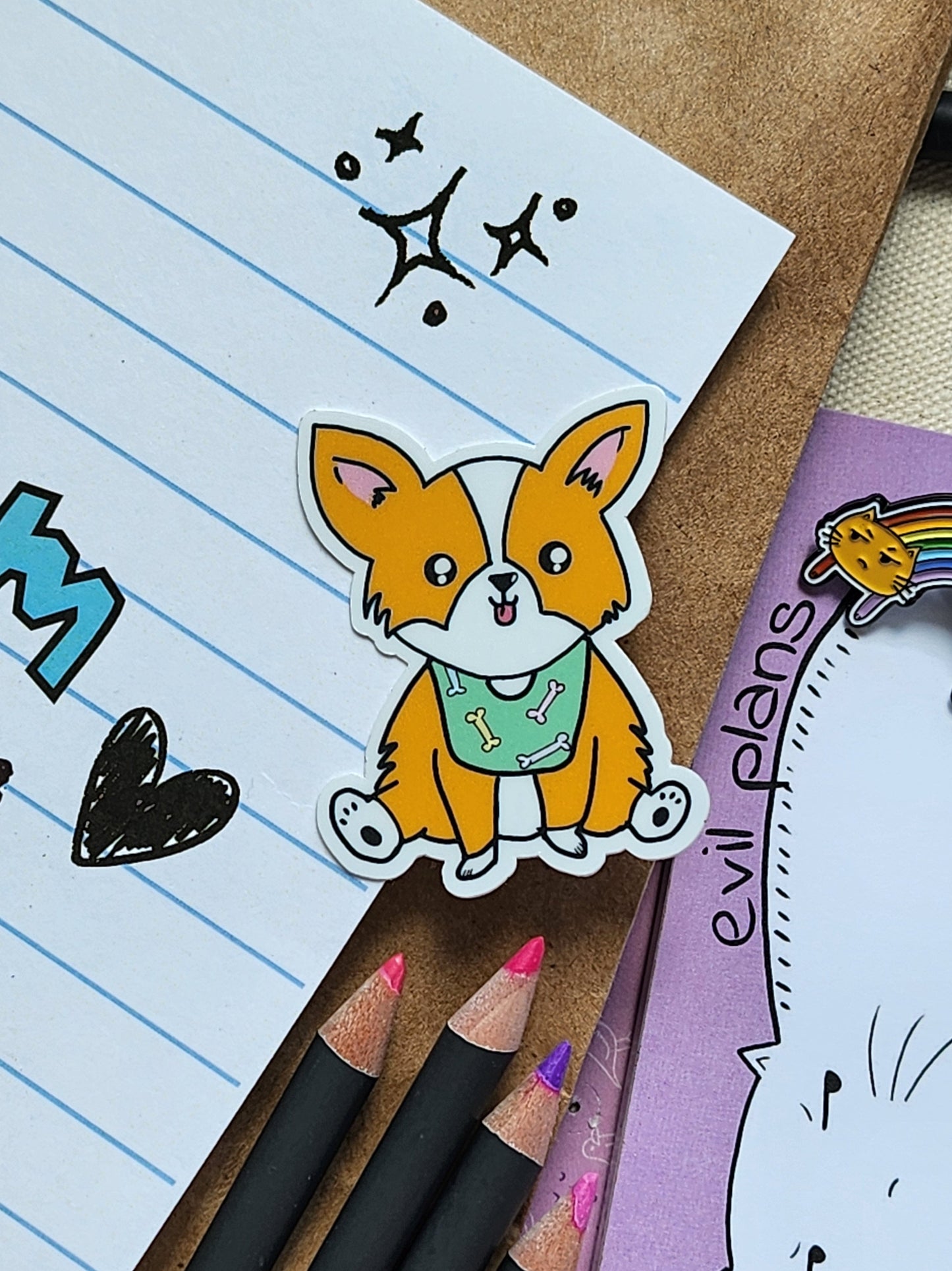 Cartoon dog sticker on lined paper with pencils and a notepad in the background