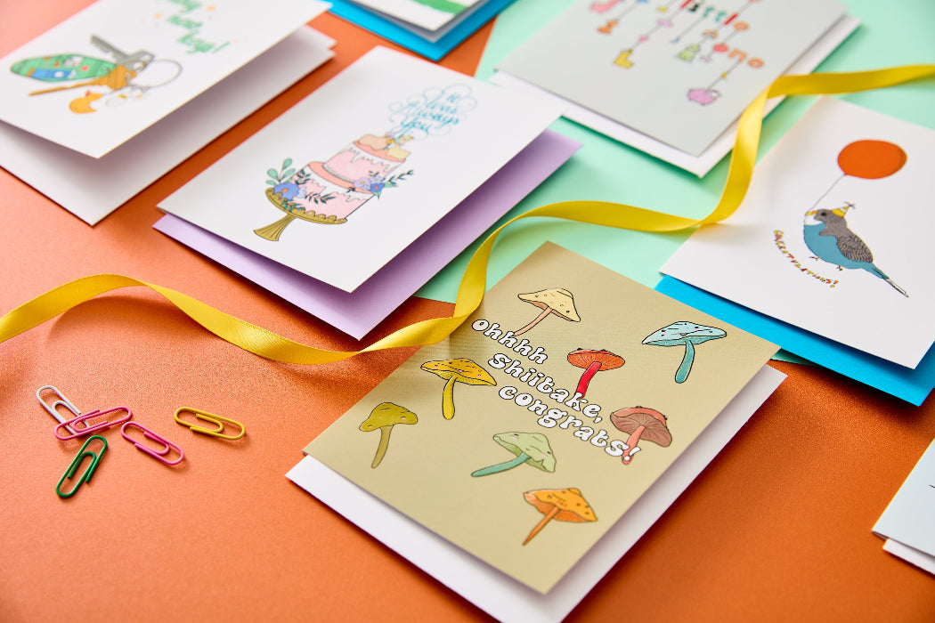 Monthly greeting card subscription featuring four cards. the image shows a selection of colourful cards on a green and orange background