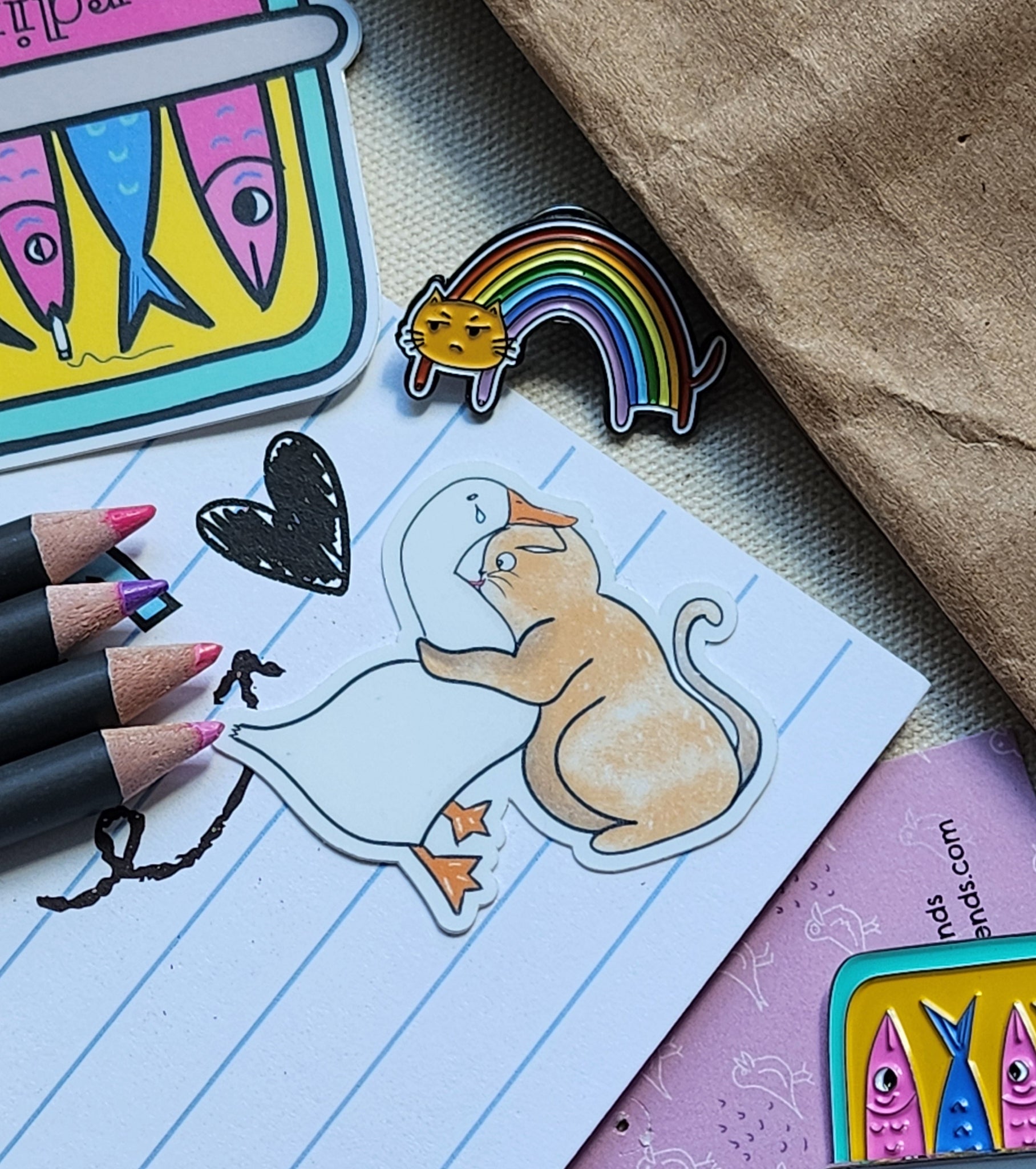 cat and duck sticker on a lined paper, with various stationery items