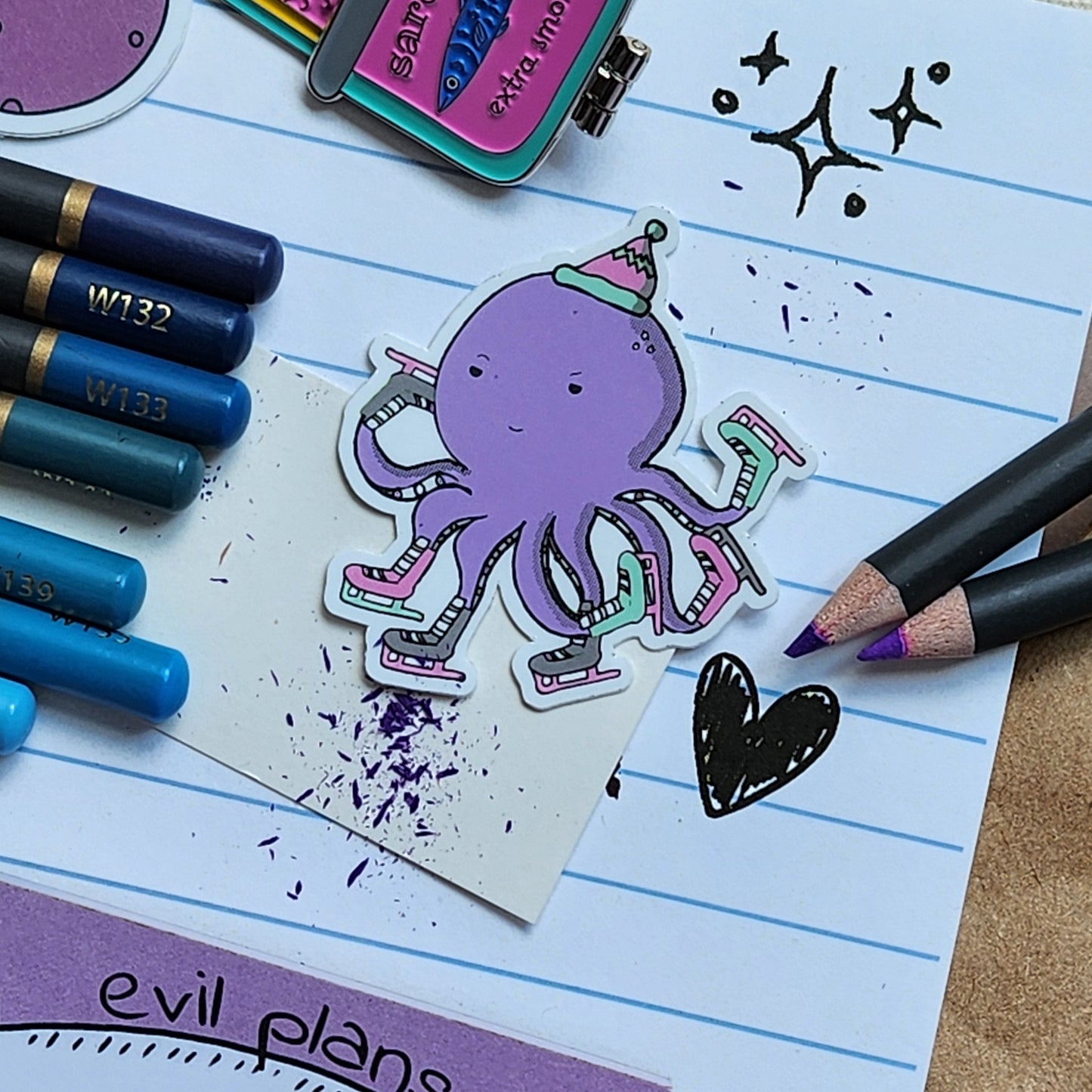 skating octopus sticker on a lined paper, surrounded by colouring pencils