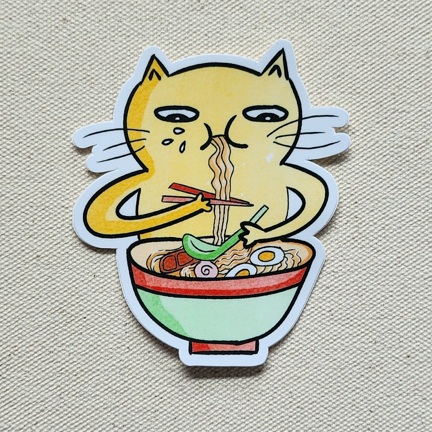 sticker of a cat eating a bowl of noodles on a beige, textured background