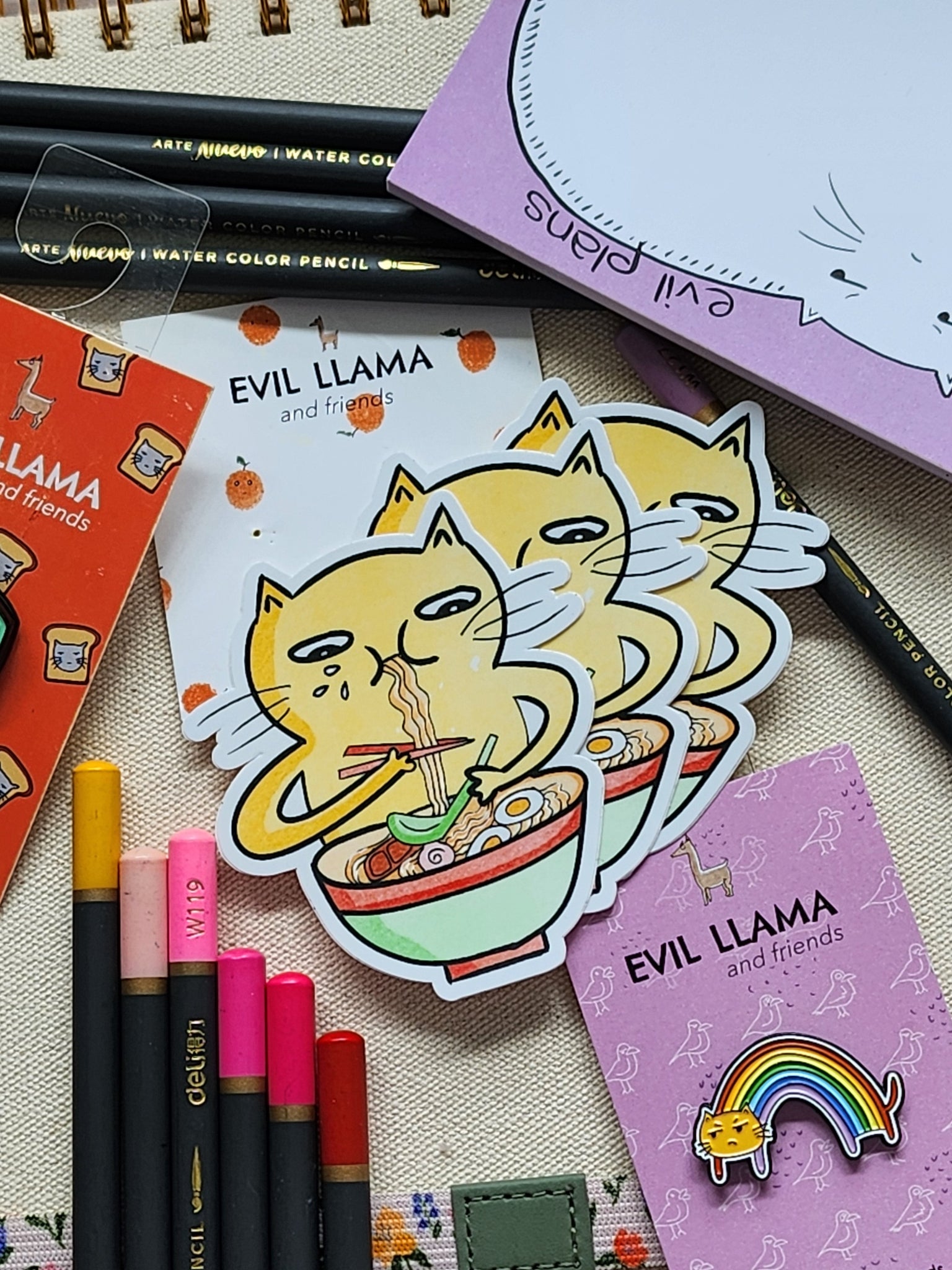 3 ramen cat stickers styled among colouring pencils and various stationery items