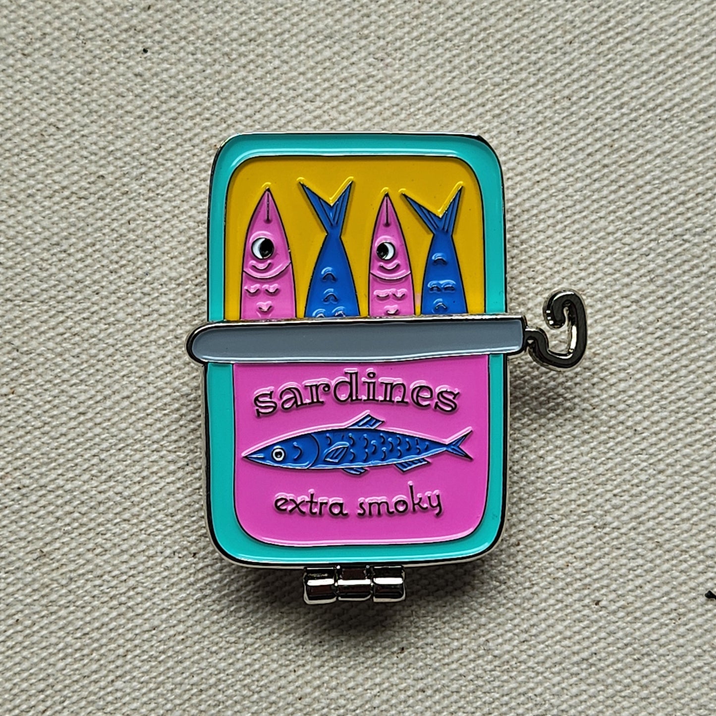 sardine can pin on textured, beige background