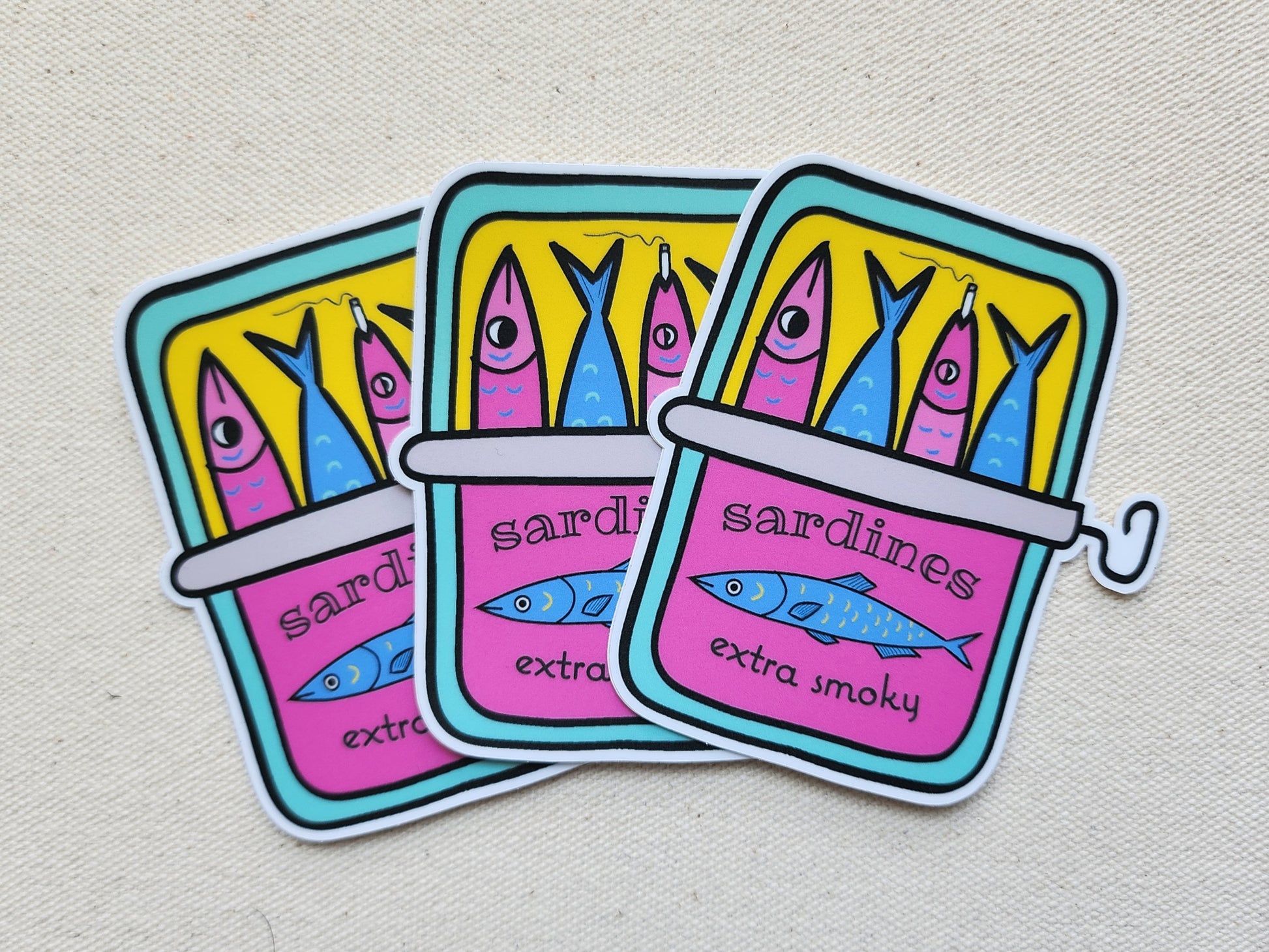 3 smoky sardines stickers on a beige, textured background
