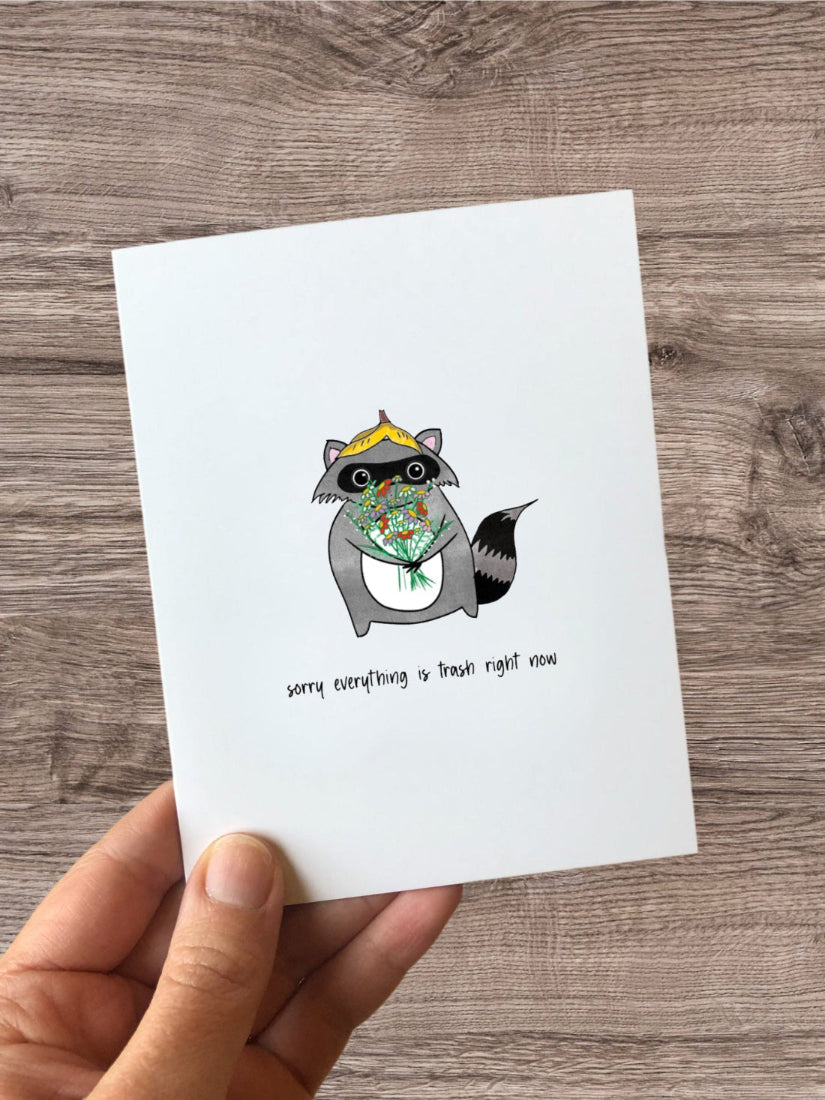 "Sorry Everything is Trash" raccoon sympathy card, blending humour and empathy with a cute raccoon design. Perfect for tough times and lighthearted support.